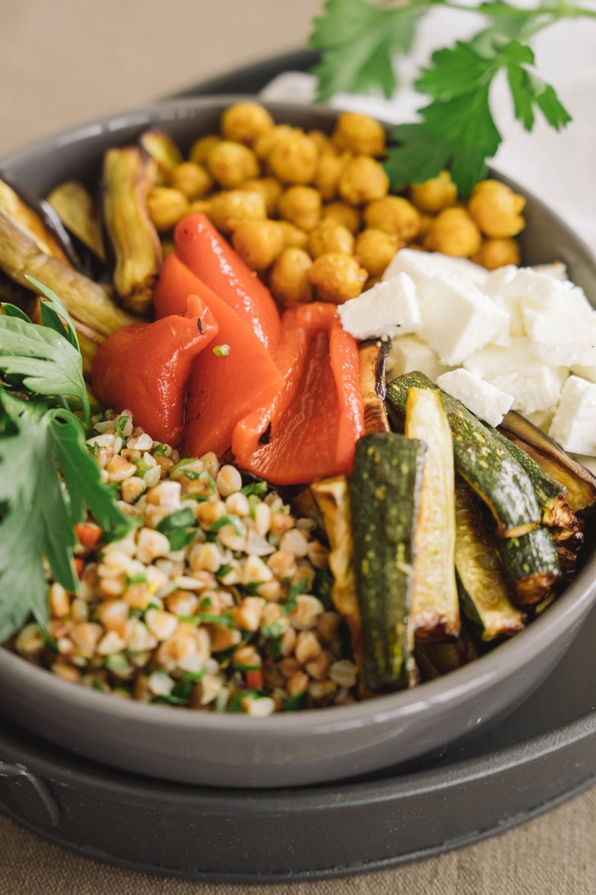 A generic Mediterranean bowl with grilled vegetables, chickpeas, and feta